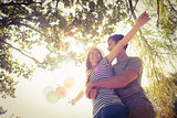 Cute couple hugging and holding balloons in the park