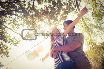 Cute couple hugging and holding balloons in the park