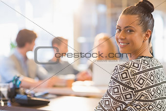 Portrait of smiling young businesswoman with colleagues
