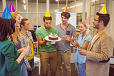 Businessman blowing candles on her birthday cake