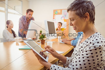 Smiling creative businesswoman using a tablet