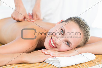 Pretty blonde enjoying a massage smiling at camera