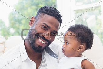 Happy father with baby girl on couch