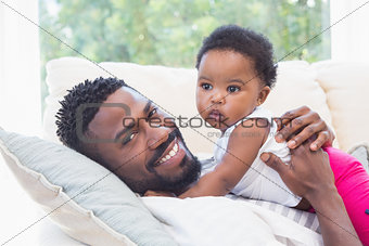 Happy father with baby girl on couch