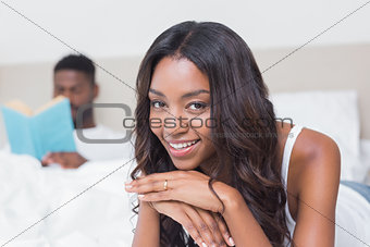 Pretty woman smiling at camera on bed
