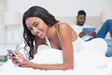 Relaxed couple using technology on bed