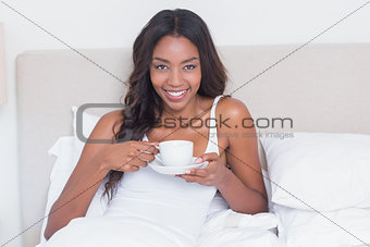 Relaxed woman drinking coffee in bed