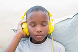 Little boy listening to music on the couch