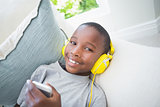 Little boy listening to music on the couch