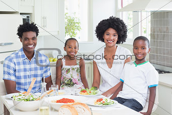 Happy family sitting down to dinner together