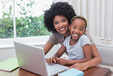Happy mother and daughter using the laptop