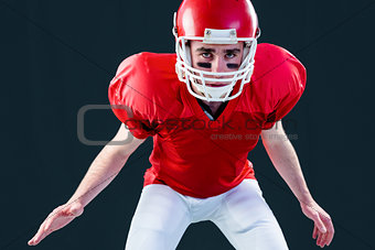 A serious american football player taking his helmet looking at camera