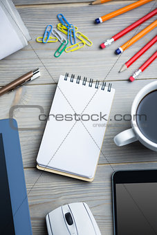 Notepad next to the cup smartphone tablet and mouse