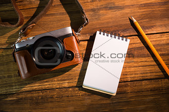 Camera next to the notepad and pen