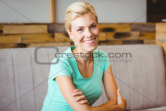 Pretty blonde woman looking at camera with arms crossed