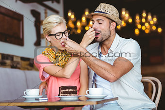 Cute couple on a date giving each other food
