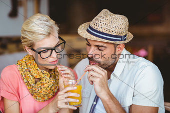 Cute couple on a date sharing an orange juice