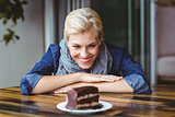 Smiling blonde looking a chocolate cake
