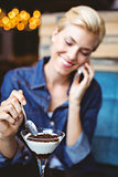 Smiling blonde eating a creamy chocolate
