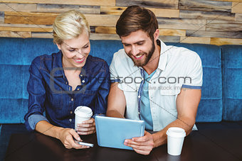 Cute couple on a date watching photos on a tablet