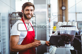 Handsome barista using the coffee machine