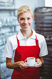 Pretty barista holding a cup of coffee