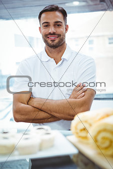 Smiling server in apron arm crossed
