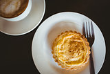 Close up view of a pastry beside a cappuccino