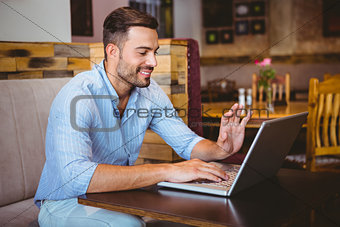 Smiling businessman using his laptop