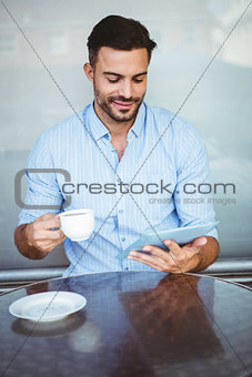 Smiling businessman using a tablet