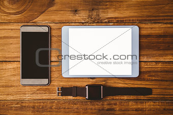 Tablet next to smartphone and swatch