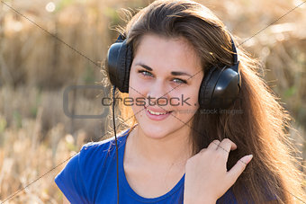 Girl listening to music in  field