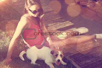 Hipster Teenage Girl with her Dog Lying on the Grass.