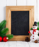Christmas still life with snowman and firtree on wooden board