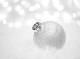 Christmas Decoration with White Ball in the Snow on the Blurred Background with Lights. Greeting Card