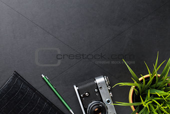 Desk with camera, supplies and flower