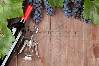 Red grape, wine bottle and corkscrew