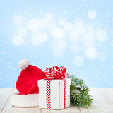 Christmas gift box, santa hat and tree branch
