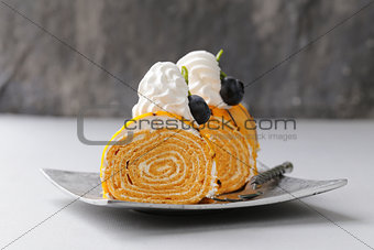 portioned dessert piece of cake with cream and chocolate on a plate