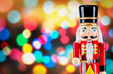 Soldier nutcracker statue standing in front of Christmas lights