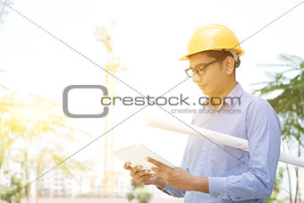 Male contractor engineer reading on tablet pc