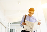 Executive reading newspaper while going to office