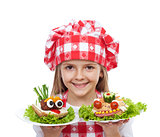 Happy little girl chef with creative sandwiches