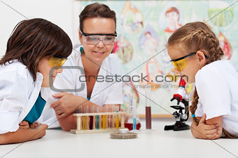 Young students watching an experiment in elementary science clas
