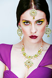 young pretty caucasian woman like indian in ethnic jewelry close up on white, bridal makeup