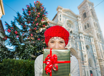 Woman tourist hiding behind christmas gift box in Florence