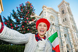 Tourist with Italian flag taking selfie in Christmas Florence