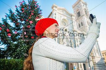 Woman tourist taking photo near Christmas tree in Florence