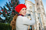 Woman tourist taking photo of Christmas decorated Florence