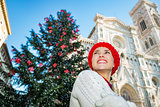 Happy young woman standing near christmas tree in Florence